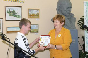 директор библиотеки Никулинская Н.Н. вручает читательский билет Почетному читателю Романову В.